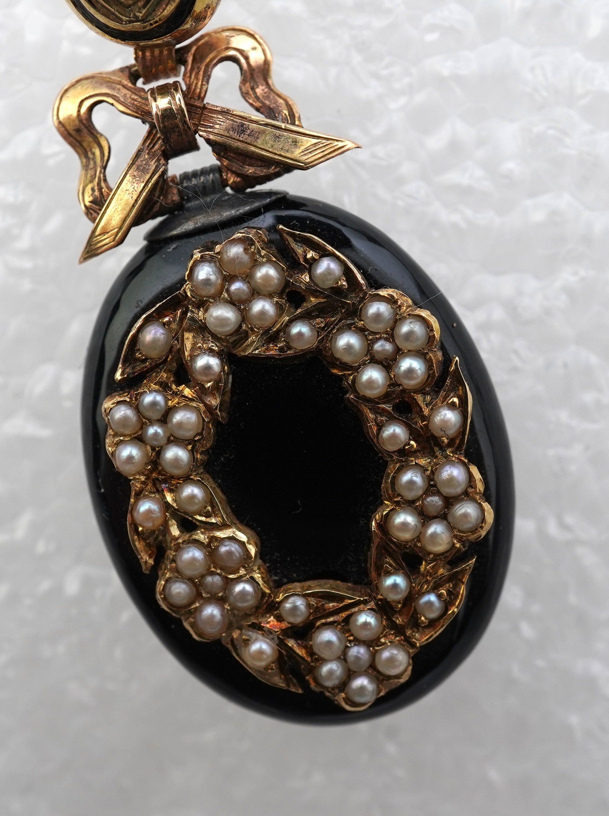 An onyx and seed pearl mourning locket pendant, late 19th century
